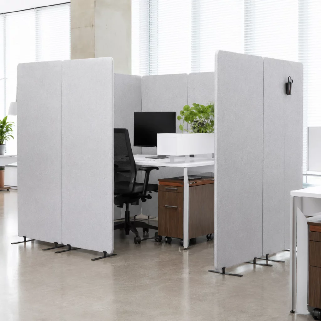 Cloisons de bureau Bilnora utilisées pour séparer plusieurs postes de travail dans un open space lumineux, créant des espaces individuels tout en conservant une circulation fluide.