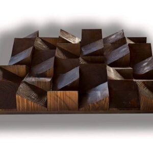 Diffuseur en bois chêne foncé au format horizontal, composé de blocs et de facettes inclinées qui créent un relief géométrique marqué, avec un veinage visible sur la surface sombre.