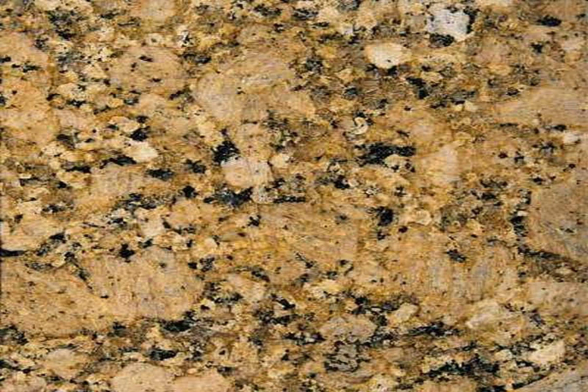Gros plan sur la texture du granit Giallo Veneziano, composé de cristaux dorés, beiges, noirs et gris formant un motif minéral chaleureux.