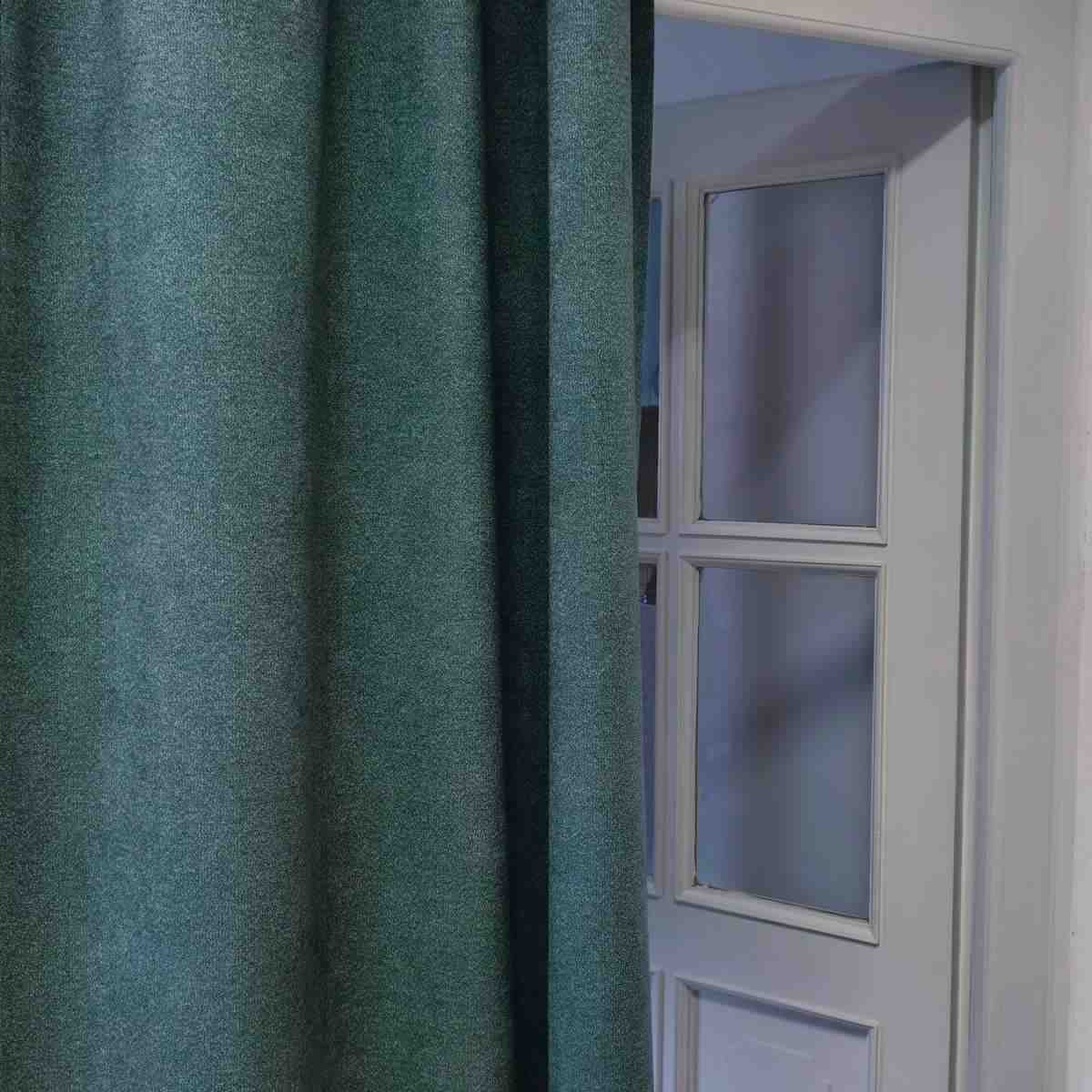 Rideau de porte acoustique Meva vert devant une porte intérieure