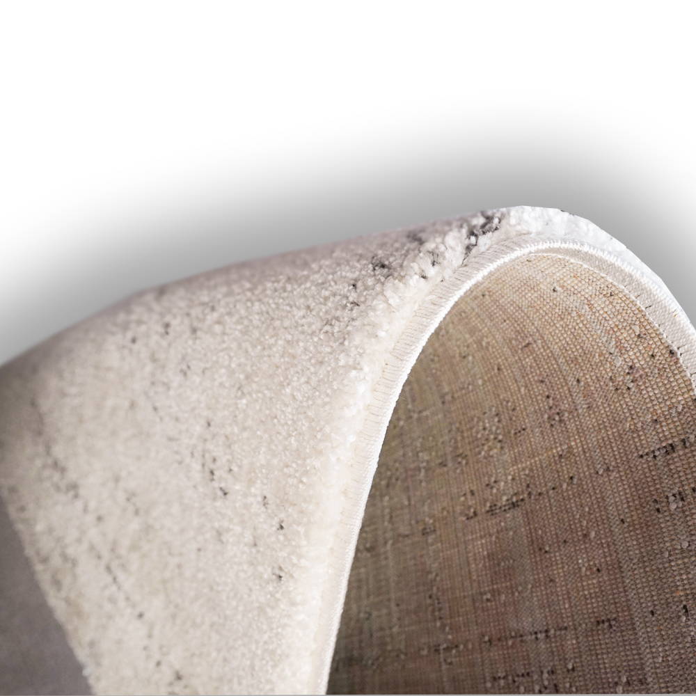 Gros plan du tapis acoustique blanc cassé Luxury Harmony montrant sa surface épaisse, sa bordure soigneusement finie et son revers textile tissé.